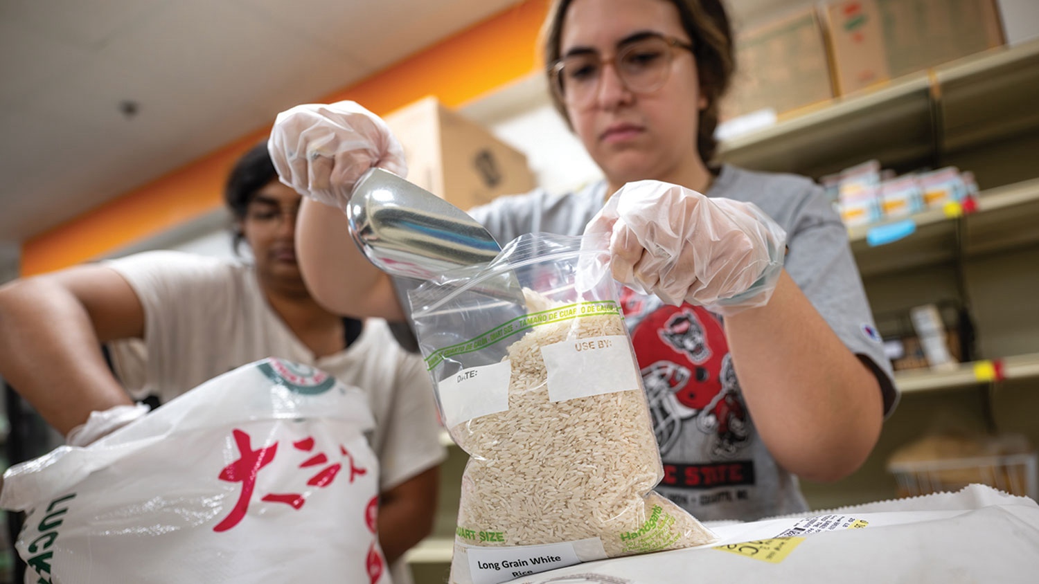 Feed the Pack volunteers filling bags of rice.