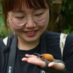 Yinan Ding holding an insect during her spring break study-abroad trip to Ecuador.