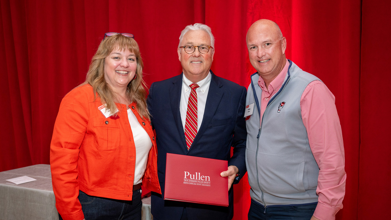 Chancellor Randy Woodson, center, presents Kristin and Brian Holder with their Pullen Society membership certificate. Photos by Becky Kirkland.