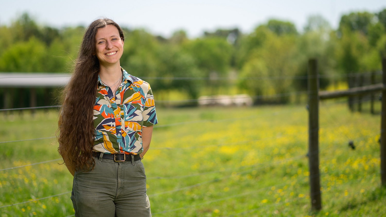 Maya Keefer standing in front of a pasture.
