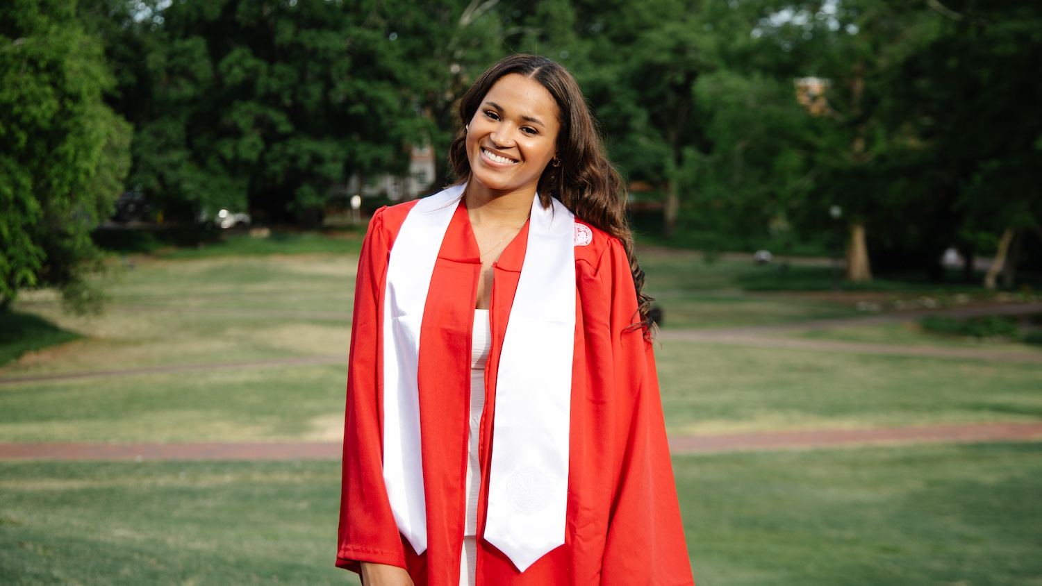 Kassidy Oliphant in her graduation robe and a whit sash